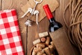 Red wine bottle, bowl with corks and corkscrew. View from above