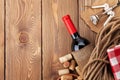 Red wine bottle, corks and corkscrew over wooden table backgroun Royalty Free Stock Photo