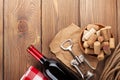 Red wine bottle, corks and corkscrew over wooden table background Royalty Free Stock Photo