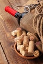 Red wine bottle, corks and corkscrew over wooden table background Royalty Free Stock Photo