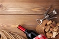 Red wine bottle, corks and corkscrew over wooden table background Royalty Free Stock Photo