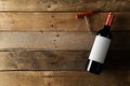 Red wine bottle with corkscrew on brown rustic wooden table flat lay from above Royalty Free Stock Photo