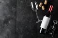 Red wine bottle with corkscrew, corks and wine glass on dark wooden table flat lay from above Royalty Free Stock Photo