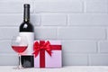 Red wine bottle with empty label, glass for tasting and gift box for romantic surprise Royalty Free Stock Photo