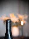 Table set with wine bottle and candle lit white lilies. Heart shaped bokeh Royalty Free Stock Photo