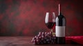 A red wine bottle, a wine glass, and a bunch of grapes arranged on a red surface with space for text, creating a simple and Royalty Free Stock Photo