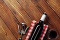 Red wine bottle, wine glass and corkscrew on wooden table background Royalty Free Stock Photo