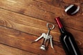 Red wine bottle, wine glass and corkscrew on wooden table background Royalty Free Stock Photo