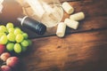 Red wine bottle with glass and grapes on wooden background Royalty Free Stock Photo