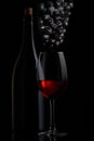 Red wine. Bottle and glass of red wine with ripe grapes still life. On a black background. with space for your text
