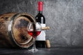 Red wine bottle with glass for tasting and wooden barrel in dark cellar Royalty Free Stock Photo