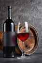 Red wine bottle with glass for tasting and wooden barrel in dark cellar Royalty Free Stock Photo