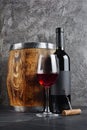 Red wine bottle with glass for tasting and wooden barrel in dark cellar Royalty Free Stock Photo