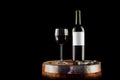 Red wine bottle and glass on a wooden barrel - isolated on black Royalty Free Stock Photo