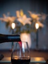 Table set with wine bottle and candle lit white lilies. Heart shaped bokeh Royalty Free Stock Photo