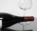A bottle of wine on its side with an empty wine glass Royalty Free Stock Photo