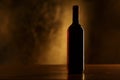 Red wine bottle silhouette on wooden table and golden background Royalty Free Stock Photo