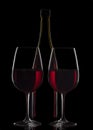 Red wine bottle and two wine glasses on black background Royalty Free Stock Photo