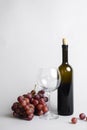 Red wine in a bottle, wine glass and red grapes over white background, isolated on white. Royalty Free Stock Photo