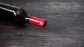 Red wine bottle on wooden background.