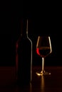 Red wine bottles and glass silhouette on wooden table and black background Royalty Free Stock Photo