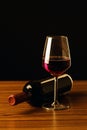 Red wine bottles and glass on wooden table and black background Royalty Free Stock Photo