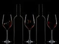 Red wine bottles and splashing red wine in glasses on dark background Royalty Free Stock Photo