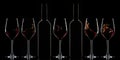 Red wine bottles and splashing red wine in glasses on dark background Royalty Free Stock Photo