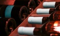 Red wine bottles stacked in a row on wooden racks, shot with limited depth of field. Close up Royalty Free Stock Photo