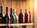 Red wine bottles on a wooden rack. Winery, bar, or store banner background. Royalty Free Stock Photo