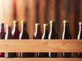 Red wine bottles on a wooden rack. Winery, bar, or store banner background. Royalty Free Stock Photo