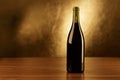 Red wine bottles wooden table and gold background Royalty Free Stock Photo