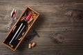 Red wine in a box with a glass and a corkscrew on a wooden table. Top view with space for your greetings Royalty Free Stock Photo