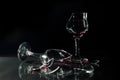 Red Wine in Broken Glass Cups Spilled on the Glass Table Isolated on Black Royalty Free Stock Photo