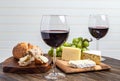 Red wine, cheese, grapes and bread on wood platter Royalty Free Stock Photo