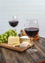 Red wine, cheese, grapes and bread on wood platter Royalty Free Stock Photo