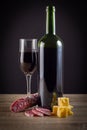 Red wine, cheese and salami on wooden table. Royalty Free Stock Photo