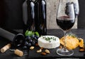 Red wine in classic glass with wine bottles composition. Elegant Wine bar with cheese plate with camembert cheese and Royalty Free Stock Photo