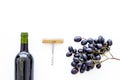 Red wine concept. Glass bottle with beverage near bunch of grapes and corkscrew on white background top view space for Royalty Free Stock Photo