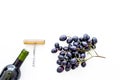 Red wine concept. Glass bottle with beverage near bunch of grapes and corkscrew on white background top view space for Royalty Free Stock Photo