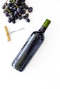 Red wine concept. Glass bottle with beverage near bunch of grapes and corkscrew on white background top view space for Royalty Free Stock Photo