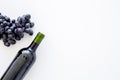 Red wine concept. Glass bottle with beverage near bunch of grapes on white background top view copy space Royalty Free Stock Photo