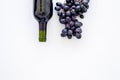 Red wine concept. Glass bottle with beverage near bunch of grapes on white background top view copy space Royalty Free Stock Photo