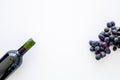 Red wine concept. Glass bottle with beverage near bunch of grapes on white background top view copy space Royalty Free Stock Photo