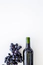 Red wine concept. Glass bottle with beverage near bunch of grapes on white background top view copy space Royalty Free Stock Photo