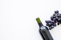 Red wine concept. Glass bottle with beverage near bunch of grapes on white background top view copy space Royalty Free Stock Photo