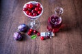 Red wine in a decanter. cherry in a glass. plum on the table Royalty Free Stock Photo