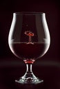 Red wine drop splashing inside glass close up Royalty Free Stock Photo