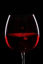 Red wine.Drops of wine fall in glass .Black background Royalty Free Stock Photo