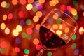 Red wine glass against christmas lights bokeh background Royalty Free Stock Photo